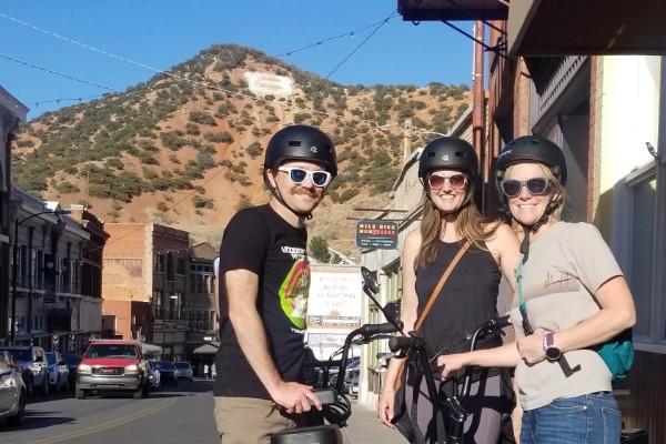 Three friends with their e-bikes on the streets of Bisbee, Arizona