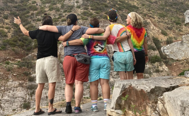 Group of five people hugging each other